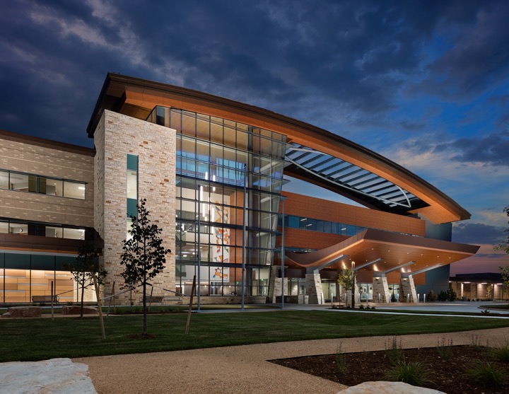 The exterior palette of materials speaks to the Mountain West locale where residents' hold a deep connection to the outdoors. Colorado Buff stone, brick and wood give the building a native materiality that grounds the structure. Photography by Jim Roof. 