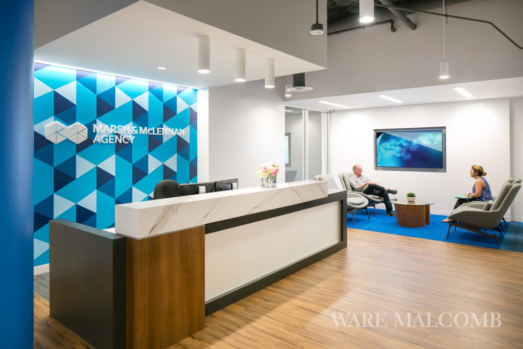 A custom wall covering behind the reception desk is based on the corporate logo. The hexagonal shape is repeated throughout the wall covering.